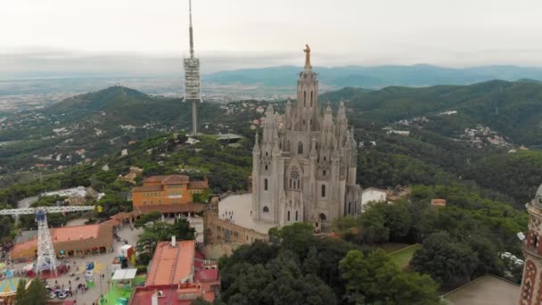 バルセロナ スペイン ティビダボ遊園地とカトリック教会の空中パノラマビュー有名なティビダボ山から遊園地とイエスの神聖な心の寺院 カトリック教会 — ストック動画