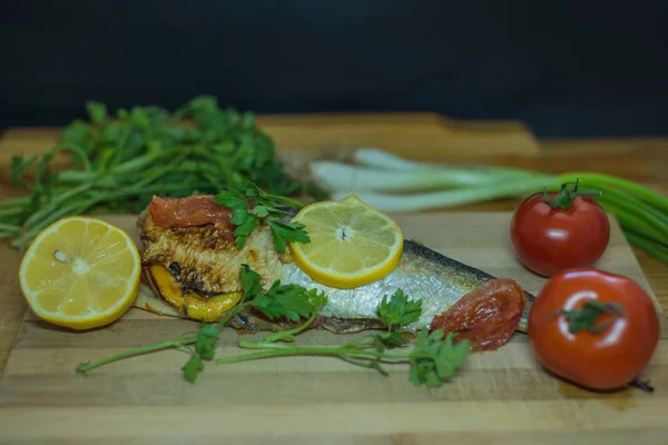 fish cooking with vegetables and lemon