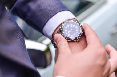 arabanın yanında kol saati ile işadamı