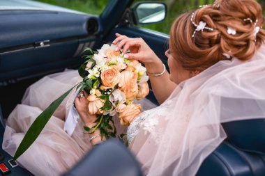  arabada çiçek buketi ile gelin