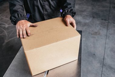 Elinde karton kutu olan bir adam.