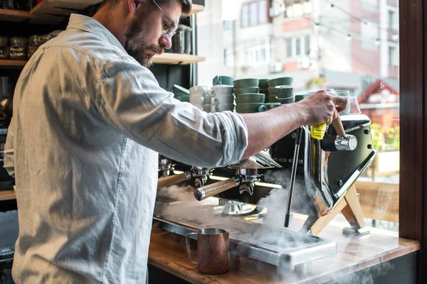 Barmen kahve makinesinde kahve hazırlar.