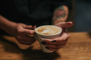 Bir fincan kahve tutarken.