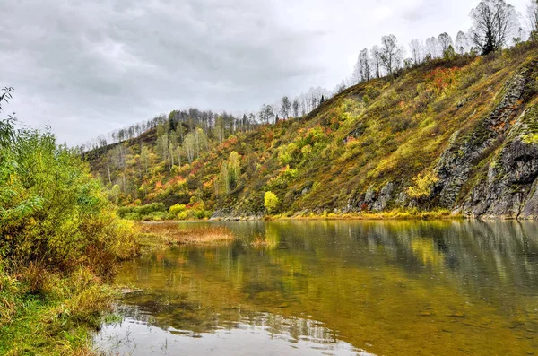 Herbstliche Landschaft am felsigen Steilufer des Gebirgsflusses — Stockfoto