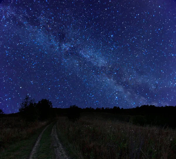 星空と天の川銀河と美しい夜の農村風景 秋の牧草地を通って汚れた道を輝く星 夜の闇の中に輝く星の光 — ストック写真