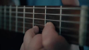 Müzisyen akustik gitar parmakları el yakın oynarken.