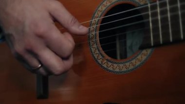 Müzisyen akustik gitar parmakları el yakın oynarken.