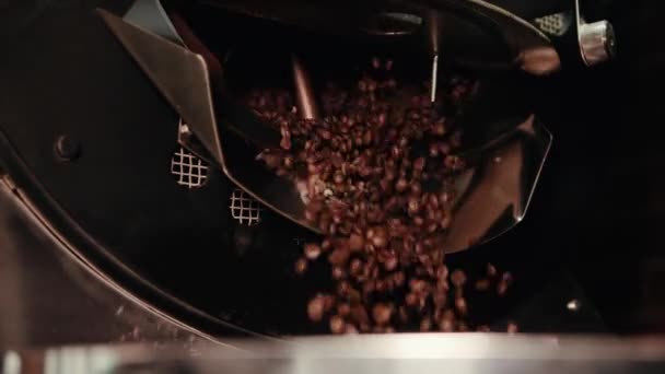 一个男人正在操作一台咖啡机 他打开铁容器 棕色的烤咖啡豆掉进一个大钢碗里 有一个旋转的轮子 — 图库视频影像