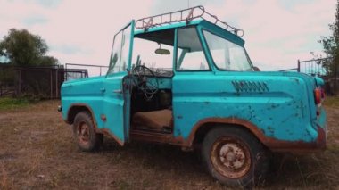 Bir kapı açık bir çayır üzerinde tuhaf bir eski retro su renkli araba.