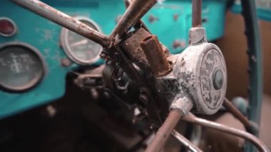 Bir direksiyon simidi, bir ön cam, bir kontrol panosu ve garip bir eski deniz yeşili araba yolcu koltuğu.