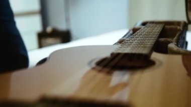 Bir gitarist elini gitarın üzerinden geçiriyor ve onu alıyor..