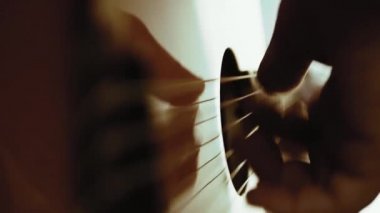 Müzisyen akustik gitar çalıyor. Altın yüzük ile parmaklar dizeleri dokunmadan. Belki de acemi gitarist ilk akorları öğrenme. Ya da belki müzik öğretiyorya ya da bir düğün grubunda çalıyordur..