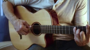 Müzisyen akustik gitar çalıyor. Altın yüzük ile parmaklar dizeleri dokunmadan. Belki de acemi gitarist ilk akorları öğrenme. Ya da belki müzik öğretiyorya ya da bir düğün grubunda çalıyordur..