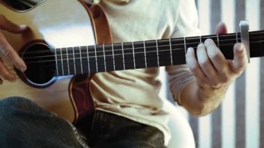 Müzisyen akustik gitar çalıyor. Altın yüzük ile parmaklar dizeleri dokunmadan. Belki de acemi gitarist ilk akorları öğrenme. Ya da belki müzik öğretiyorya ya da bir düğün grubunda çalıyordur..