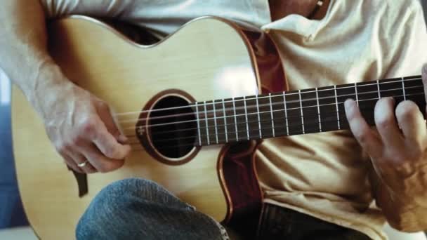 音乐家正在弹原声吉他 手指与金戒指触摸字符串 也许他是初学者吉他手学习他的第一个和弦 或者他正在教音乐或玩婚礼乐队 — 图库视频影像
