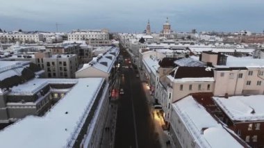 Yukarıdan büyük bir Rus şehrinin karlı çatıları ve sokakları. Araba. Doğal aydınlatma, multikopter çekim.