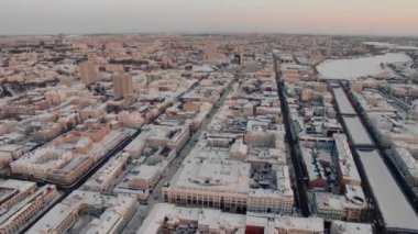 Yukarıdan büyük bir Rus şehrinin karlı çatıları ve sokakları. Kış, yollar, arabalar. Doğal aydınlatma, multikopter çekim.