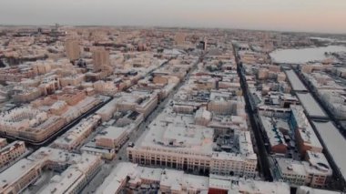 Yukarıdan büyük bir Rus şehrinin karlı çatıları ve sokakları. Kış, yollar, arabalar. Doğal aydınlatma, multikopter çekim.