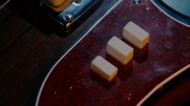 4 telli elektro gitar gövdesi, kontroller, köprü ve teller, yakın çekim. Profesyonel bir müzik ekipmanı.
