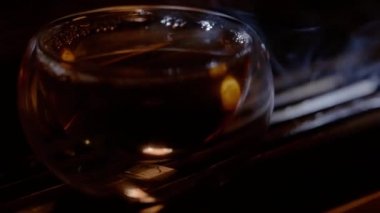 Farklı aydınlatma fermente çay ile bir cam fincan. Bu bir çay töreninin bir parçası, geleneksel Çin kültüründen bir etkinlik..