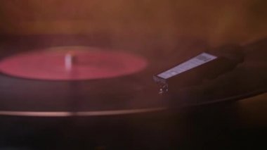 Oynatma kalemi vinil plaka üzerindedir. Albüm gramaphone'da çalıyor. Kalın beyaz bir duman kıvrılıyor..