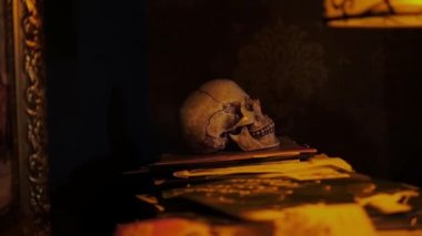 Siyahlı bir adam bir yığın el yazmasından insan kafatasını alıyor. Odanın içi karanlık, gizemli sarı mum ışığını görebiliyoruz. Sanatçılar, yazarlar, aktörler için yaratıcı bir sanat konsepti.