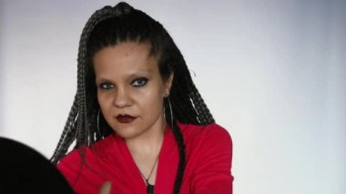 Kızıl saçlı, uzun gri afro örgülü ve koyu renk makyajlı gotik bir kız vinil plakla oynuyor. Vinil plak mağazası ya da müzik mağazası için yaratıcı bir konsept..