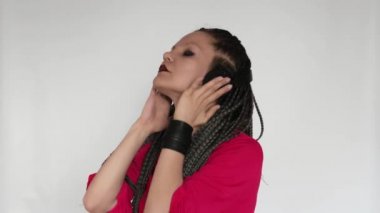 Kızıl saçlı, uzun gri örgü örgülü, koyu renk makyajlı gotik bir kız dev kulaklıklarla müzik dinliyor. Bu müzik aşığı sesten hoşlanıyor. Müzik malzemeleri mağazası ya da müzik mağazası için yaratıcı bir konsept..