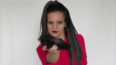 Kızıl saçlı, uzun gri örgü örgülü, koyu renk makyajlı gotik bir kız dev kulaklıklarla müzik dinliyor. Bu müzik aşığı sesten hoşlanıyor. Müzik malzemeleri mağazası ya da müzik mağazası için yaratıcı bir konsept..