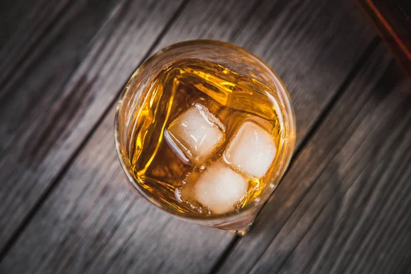 bardak viski ve bir şişe viski ahşap arka plan üzerinde