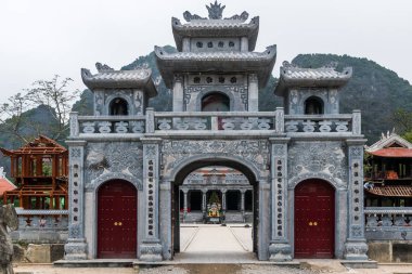 Chinese style entrance gate of the Thai Vi Temple near Trang An Landscape Complex in summer in Tam Coc, Ninh Binh, Vietnam clipart