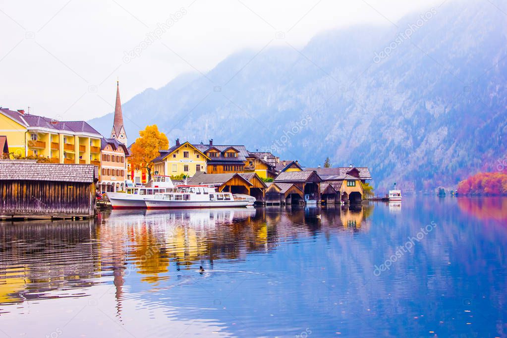 Scenic view of famous Hallstatt lakeside town reflecting in lake of Alps with beautiful light in autumn, Salzkammergut, Austria