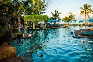 Günbatımı, Gili Trawangan, Lombok, Endonezya sırasında palms Resort tropikal Yüzme Havuzu yakınındaki plaj şezlong