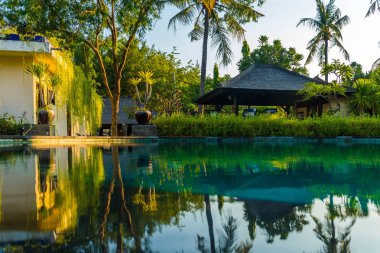 Günbatımı, Gili Trawangan, Lombok, Endonezya sırasında palms Resort tropikal Yüzme Havuzu yakınındaki plaj şezlong
