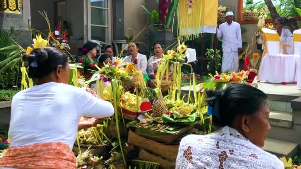 INDONÉSIE, BALI, le 30 avril 2018 - Prêtre balinais accomplissant un rituel, homme et femme prient lors d'une cérémonie et font une offrande — Video
