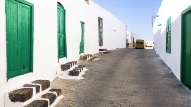 Eski yeşil ahşap kapı beyaz taş duvar zarar görmüş. Küçük bir köy sokak sahne. Teguise Lanzarote. Kanarya Adaları, İspanya. Rustik giriş ev kapalı. 4 k görüntüleri video.