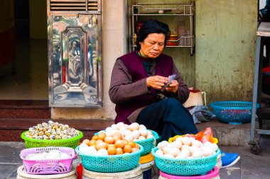 HANOI, VİETNAM - 13 Şubat 2018: Hanoi, Vietnam 'da eski bir sokak pazarında yumurta satan bir kadın.