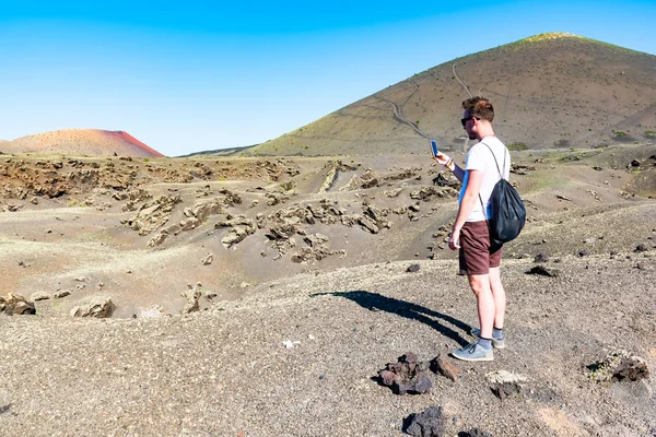 Un homme prenant des photos du paysage vulcanique de la Caldera de los Cuervos, Parc National de Timanfaya, Lanzarote, Îles Canaries, Espagne — Photo