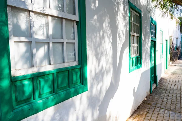 Típica casita canaria con jardín de cactus y puertas verdes o ventanas en la isla de Lanzarote, Teguise, Islas Canarias, España — Foto de Stock
