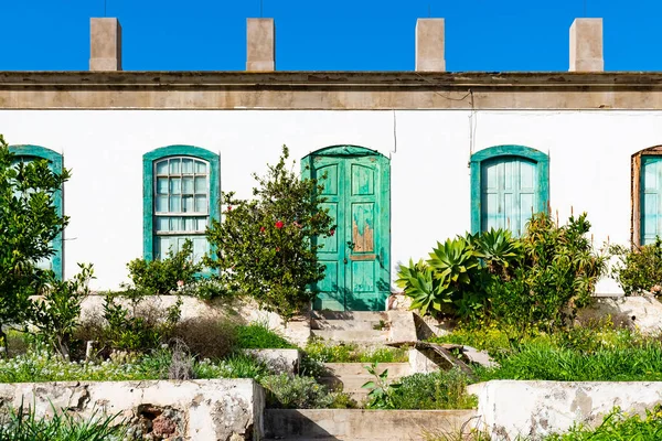 Güzel köy çıkıyor, Lanzarote, Kanarya Adaları, İspanya yıpranmış yeşil kapı ile rustical terk edilmiş eski ev