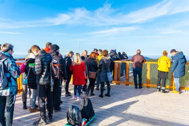PUSTEVNY, CZECH REPUBLIC, FEBRUARY 16 Şubat 2019: Doğayı izleyen ve yeni bir ahşap gözetleme kulesinde veya gökyüzünde yürüyen tanımlanamayan turistler Pustevny, korunan manzara alanı Beskids 'da ağaçlarda yürüyorlar.