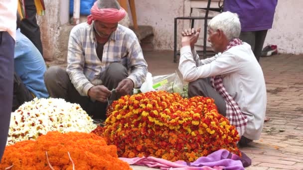 ВАРАНАСИ, Индия - 10 марта 2019 года: Неизвестные продают цветы для религиозных целей на цветочном рынке в Варанаси, Индия, 4k видео — стоковое видео
