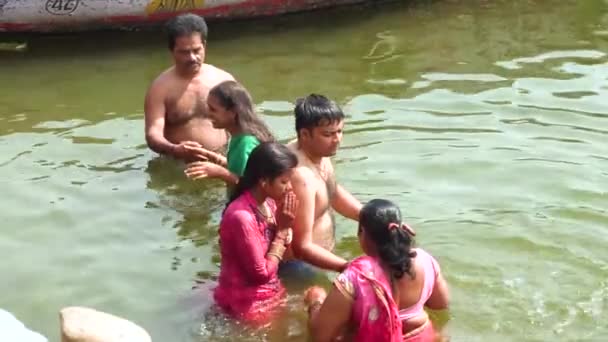 VARANASI, INDIA, MAR 10 2019 - Unidentified family taking ritual bath in the river Ganga in the holy city of Varanasi, 4k footage video — ストック動画