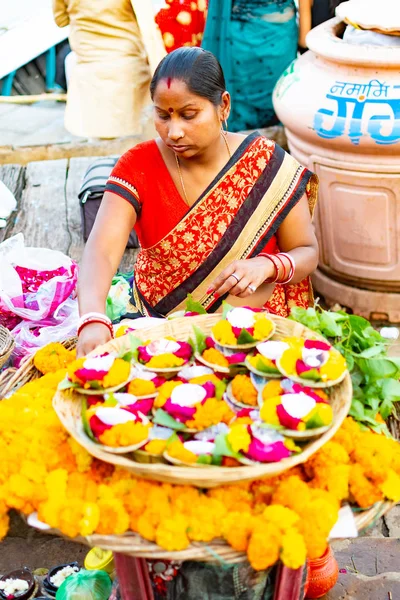 Varanasi. India, 10 mar 2019 - Una mujer india que vende velas florales para flotar como ofrendas en el río Santo Ganges en Varanasi, en la región de Uttar Pradesh, India — Foto de Stock