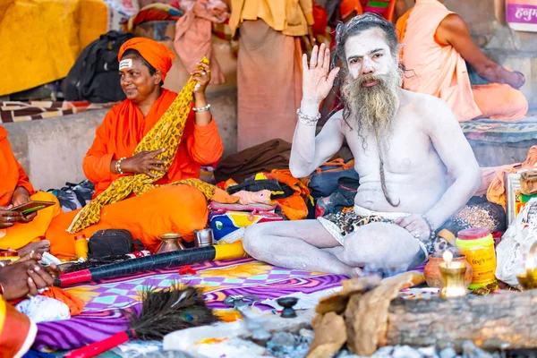 VARANASI, INDIA, 10 DE MARZO DE 2019 - El hombre santo hindú no identificado Sadhu, se sienta en el ghat cerca del río Ganges en Varanasi, India — Foto de Stock
