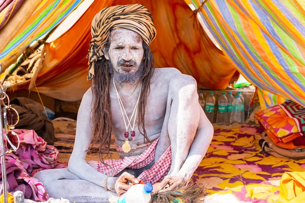 VARANASI, INDIA, 10 DE MARZO DE 2019 - El hombre santo hindú no identificado Sadhu, se sienta en el ghat cerca del río Ganges en Varanasi, India — Foto de Stock