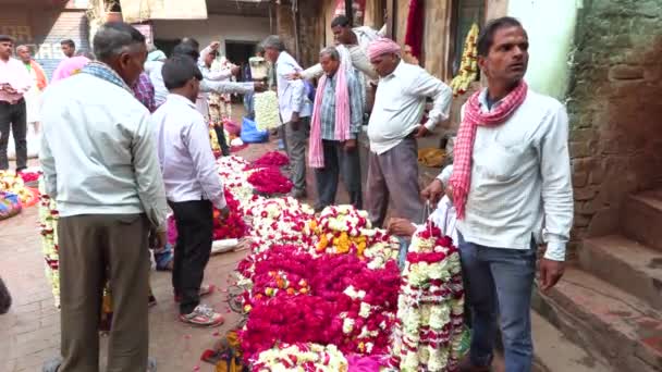 VARANASI, INDIA, MAR 14 2019 - Unidentified people sell flowers for the for the religious purposes at the riverside of Ganga in Flower marker, Varanasi, India, 4k footage video — Stock video