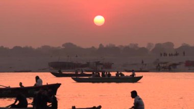 Hindistan, Varanasi, 14 Mar 2019-tekneler ve tanımlanamayan insanların siluetleri nehir Ganga, 4k video videoyu kıyısında gündoğumu sırasında güneşe dua gerçekleştirme