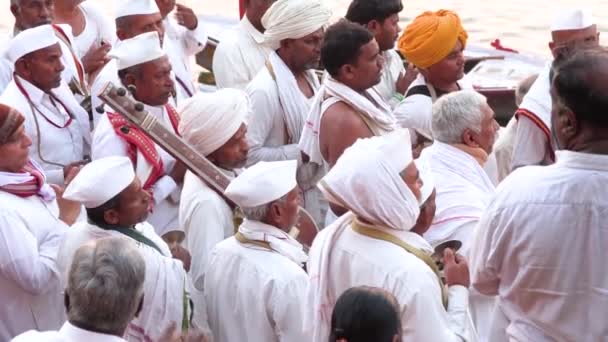 Índia, Varanasi, 14 de março de 2019 - Vista de músicos desconhecidos e outras pessoas em uma procissão como parte da cerimônia pela manhã perto do Rio Ganga, vídeo de filmagem 4k — Vídeo de Stock