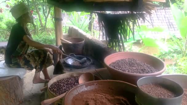 Bali, Indonesië, 10 april 2019: oude vrouw braden luwak koffiebonen in Ubud, Bali, 4k videobeelden — Stockvideo